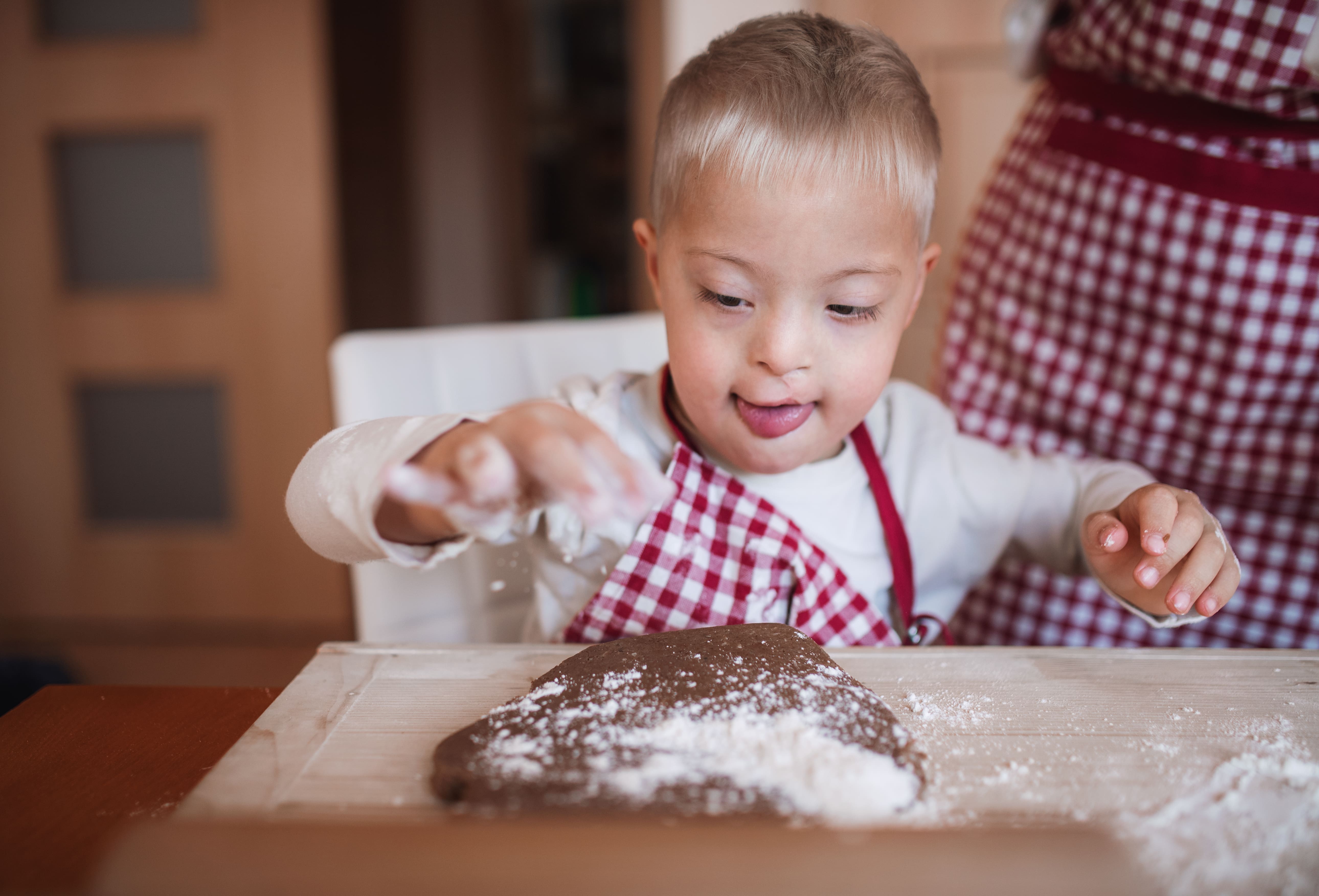 A young child molding cookie dough and baking Holiday recipes for kids.